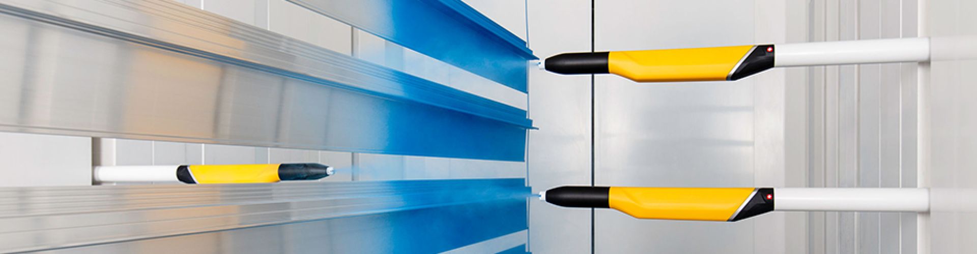 Powder coating guns spraying an aluminium extrusion